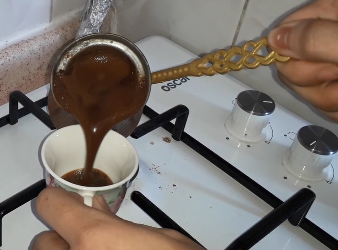 turkish coffee foam being transferred into the cup